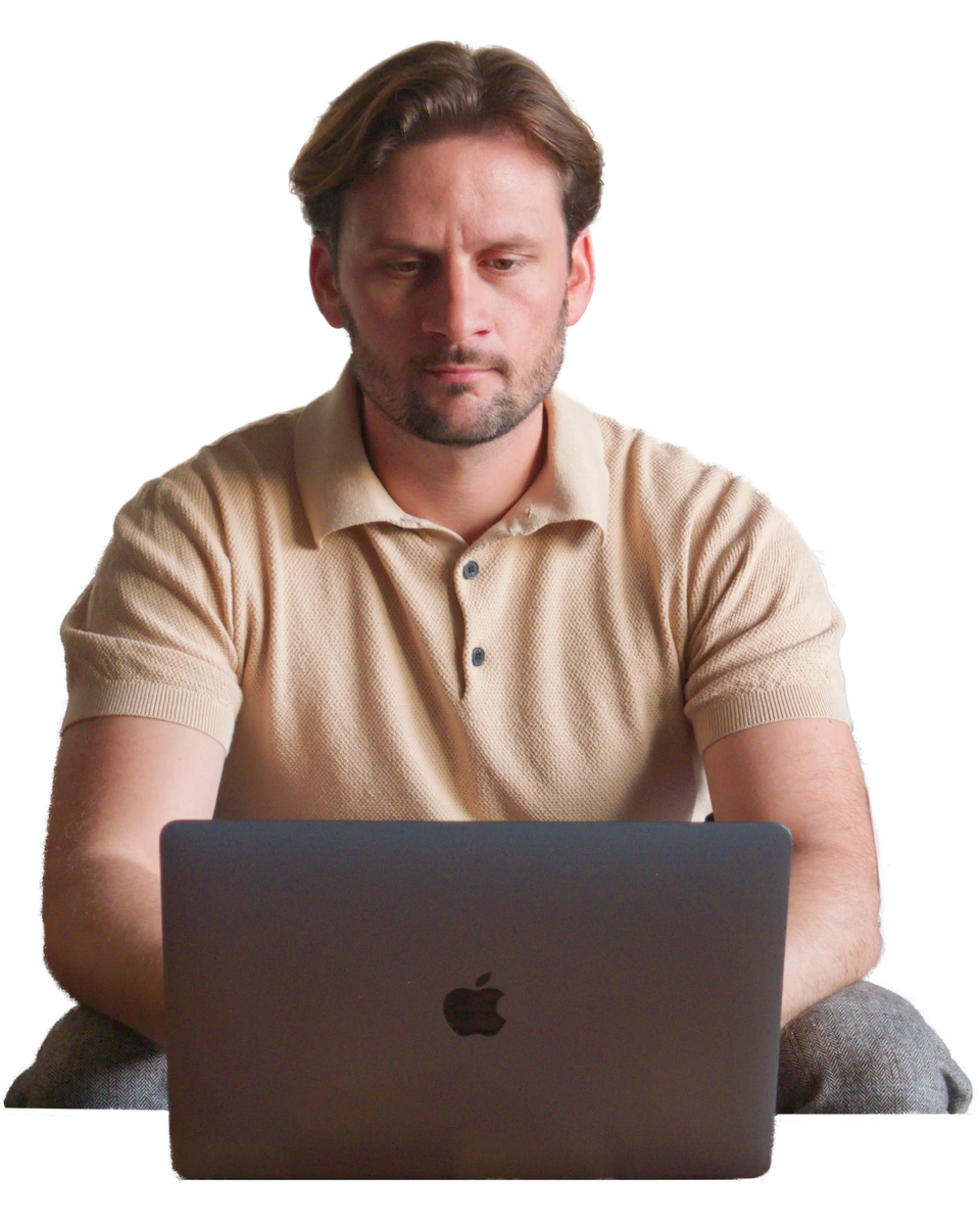 Billy Nightingale sitting at his MacBook working on web design